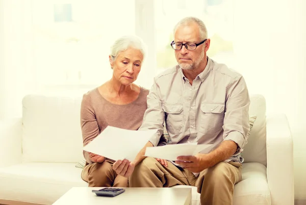 Senior paar met papieren en rekenmachine thuis — Stockfoto