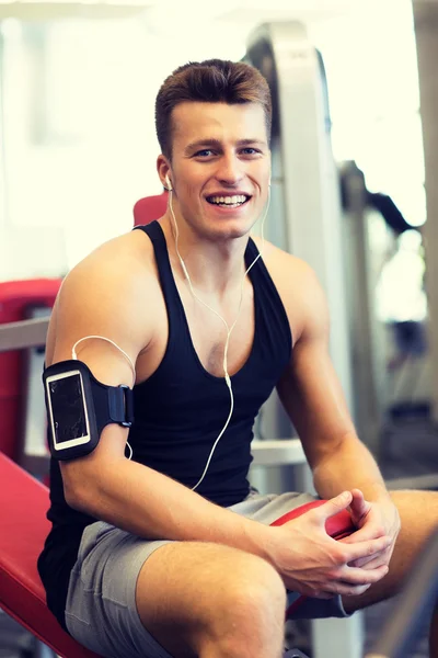 Deportista sonriente con smartphone y auriculares —  Fotos de Stock