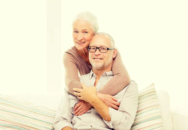 Щаслива старша пара обіймає диван вдома — стокове фото