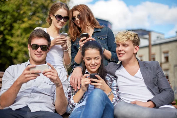 Estudiantes o adolescentes con smartphones en el campus — Foto de Stock