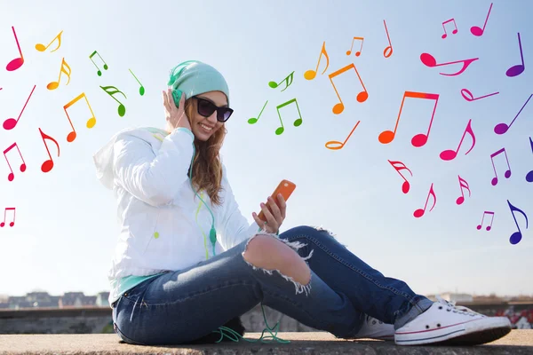Happy young woman with smartphone and headphones — Stock Photo, Image