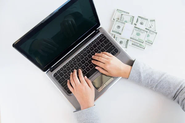 Nő kezében laptop és a pénz a Közelkép — Stock Fotó