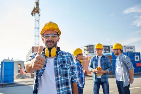 Constructores mostrando pulgares hacia arriba en el sitio de construcción —  Fotos de Stock