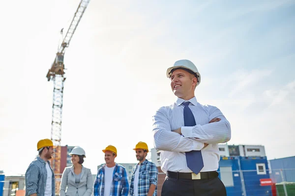 Zufriedene Bauarbeiter und Architekten auf der Baustelle — Stockfoto