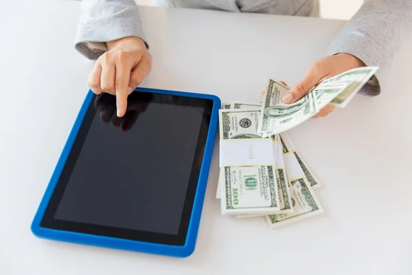 Close-up de mãos de mulher com tablet pc e dinheiro — Fotografia de Stock