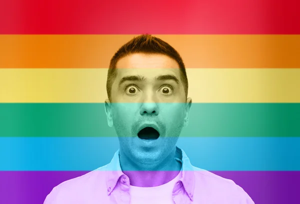 Shocked gay man shouting over rainbow flag — 스톡 사진