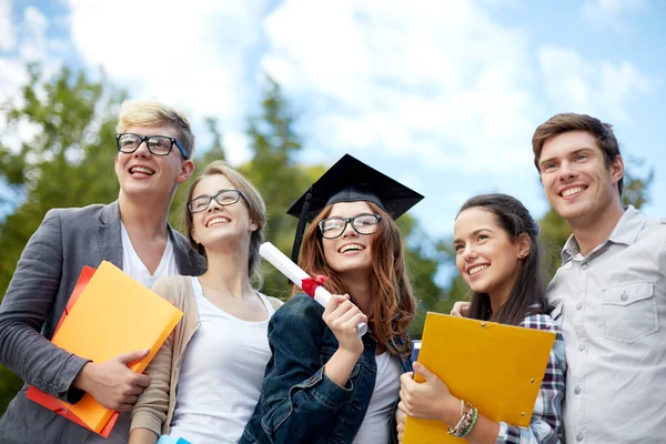 Grupo de estudiantes sonrientes con diploma y carpetas —  Fotos de Stock