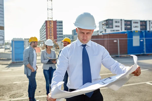 Arquitecto con plano en obra — Foto de Stock