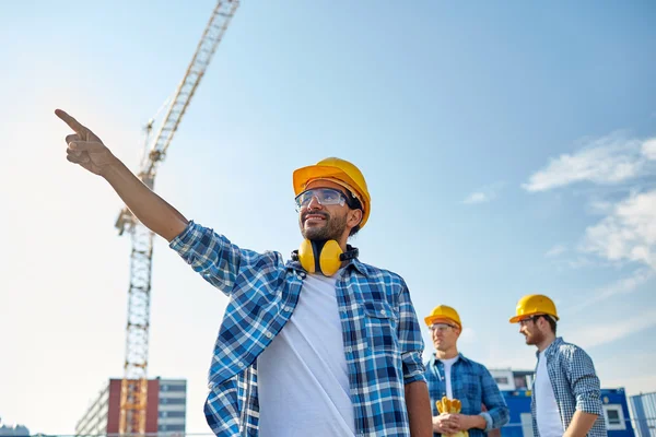 Construtores apontando dedo de lado na construção — Fotografia de Stock