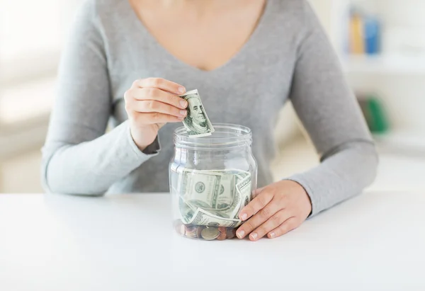 Primer plano de las manos de la mujer y el dinero del dólar en frasco —  Fotos de Stock