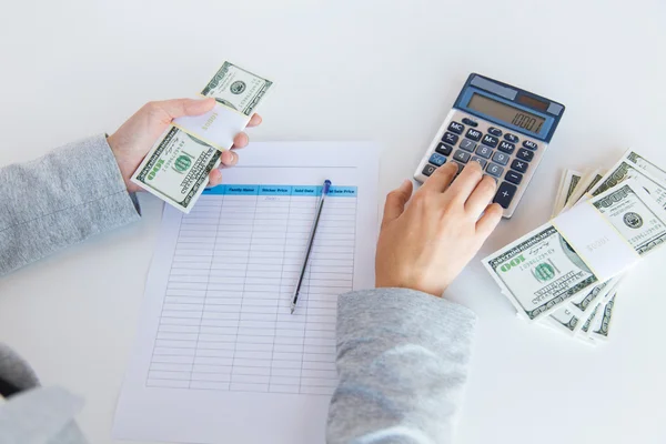 Close up of hands counting money with calculator — Stock Photo, Image