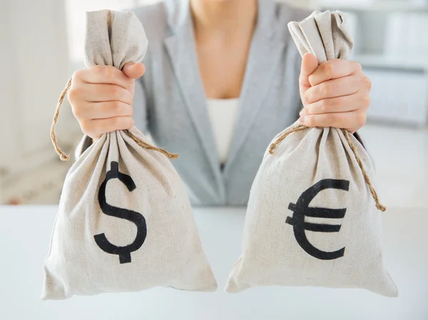 Close up of woman hands holding money bags — Stock Photo, Image