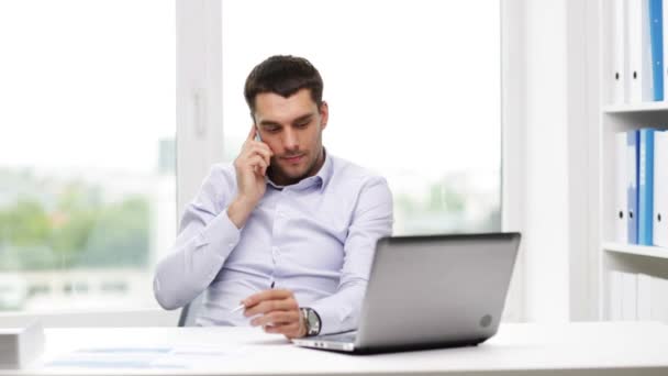 Businessman with laptop calling on smartphone — Stock Video