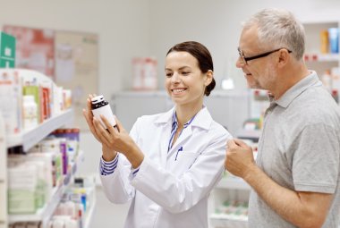 pharmacist showing drug to senior man at pharmacy clipart