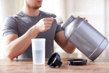 close up of man with protein shake bottle and jar clipart