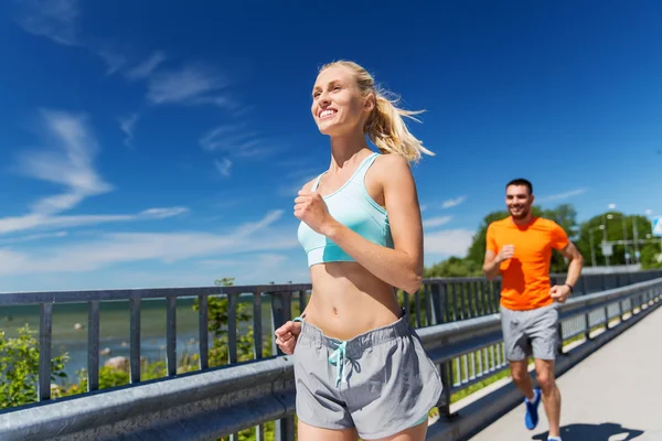 Sonriente pareja corriendo en verano junto al mar —  Fotos de Stock