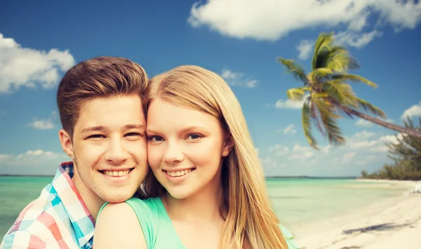 Sonriente pareja abrazándose sobre playa fondo —  Fotos de Stock