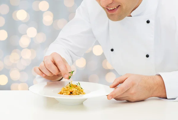 Close up of happy male chef cook decorating dish — Stockfoto