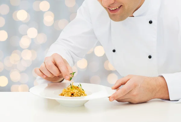 Primer plano de cocinero macho feliz plato de decoración —  Fotos de Stock