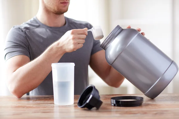 Close up of man with protein shake bottle and jar — Stock Photo, Image