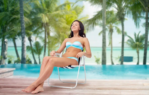 Happy young woman sunbathing in bikini on beach — Stockfoto