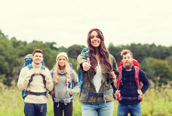 Groep lachende vrienden met rugzakken wandelen — Stockfoto