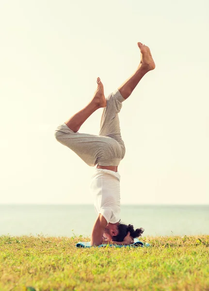 Man att göra yogaövningar utomhus — Stockfoto