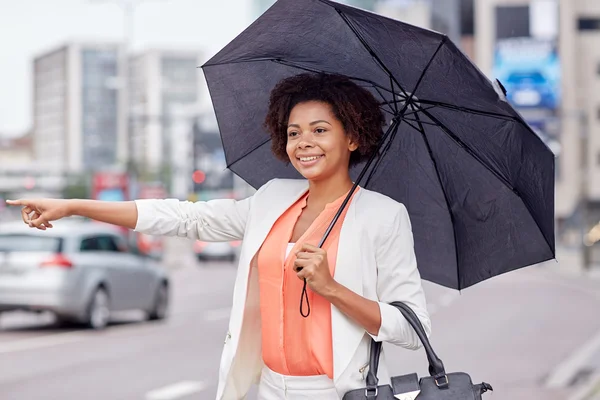 Felice donna africana con ombrello cattura taxi — Foto Stock