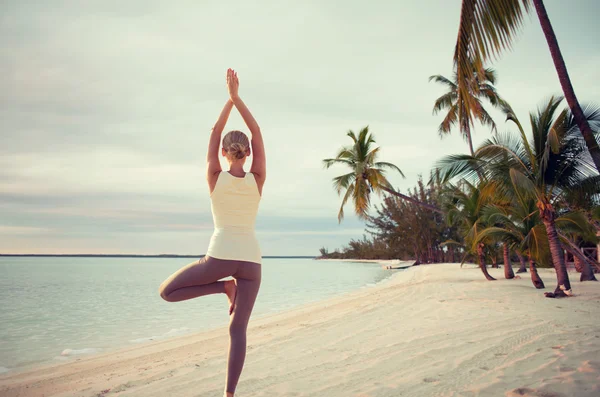 Mujer joven haciendo ejercicios de yoga al aire libre — Foto de Stock