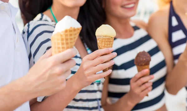 close up of happy friends eating ice cream