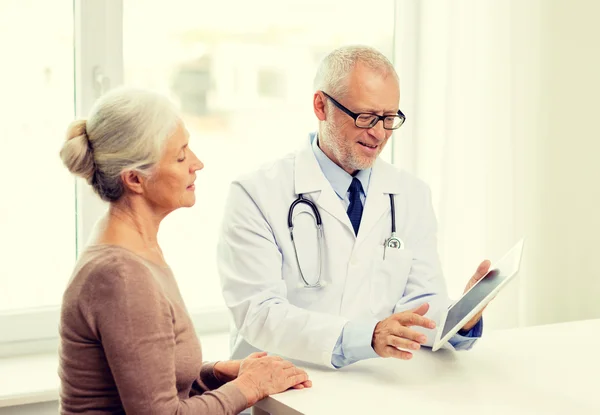 Femme âgée souriante et médecin avec comprimé pc — Photo