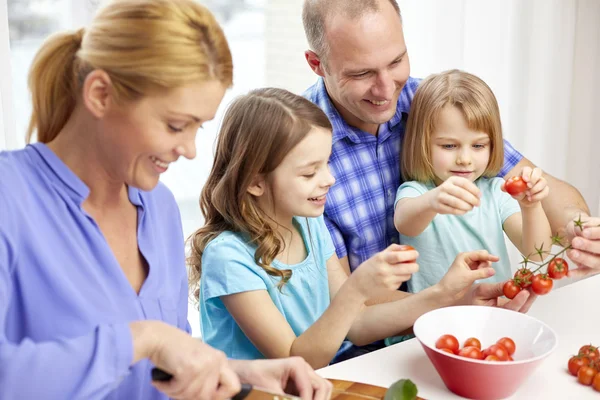 Família feliz com duas crianças cozinhar em casa — Fotografia de Stock