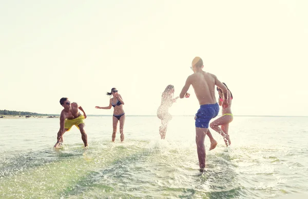 Счастливые друзья, веселящиеся на летнем пляже — стоковое фото