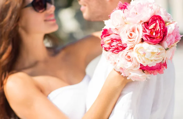 Close up of couple with bunch flowers in city — Stock Photo, Image