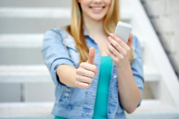 Female with smartphone showing thumbs up — Stockfoto