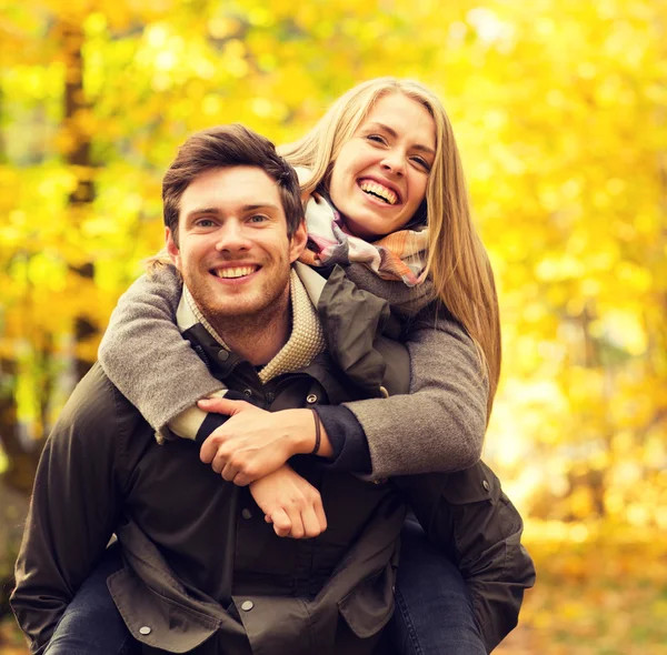 Sonriente pareja divirtiéndose en el parque de otoño — Foto de Stock