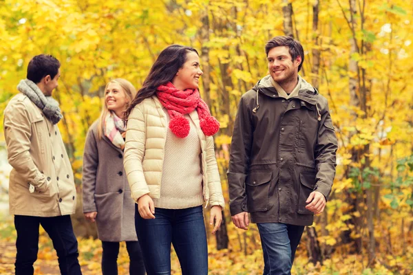 Groupe d'hommes et de femmes souriants dans le parc d'automne — Photo