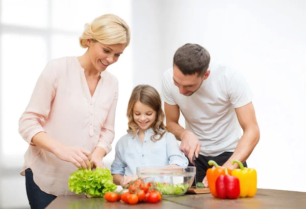 Happy family cooking vegetable salad for dinner — Stock Photo, Image