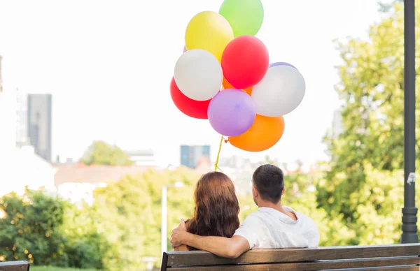 Casal feliz com balões de ar na cidade — Fotografia de Stock