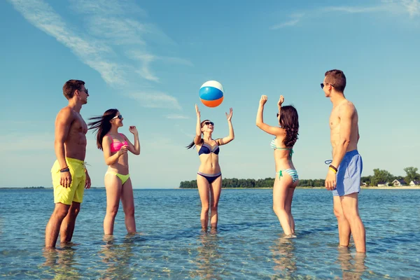 Amigos sorridentes em óculos de sol na praia de verão — Fotografia de Stock