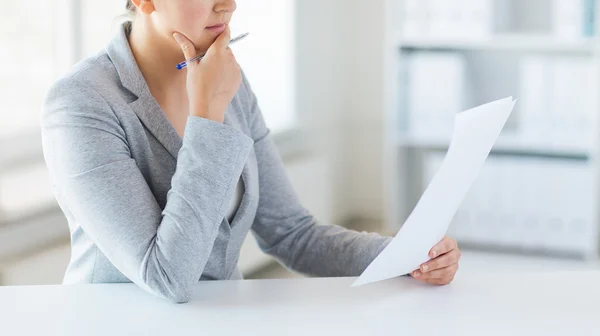 Close up of woman reading papers or tax report — Stock Photo, Image