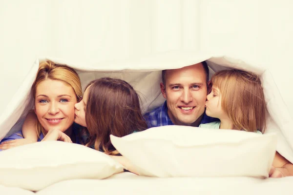 Two little girls kissing their parents on cheek — Stock Photo, Image