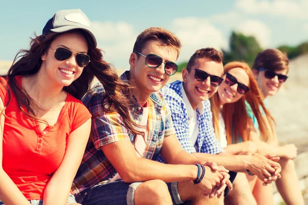 Close up of smiling friends sitting on city street — Stock Photo, Image