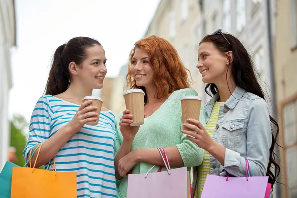 Mulheres felizes com sacos de compras e café na cidade — Fotografia de Stock
