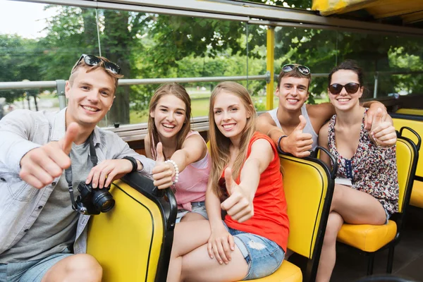 Friends traveling by tour bus showing thumbs up — Stock fotografie