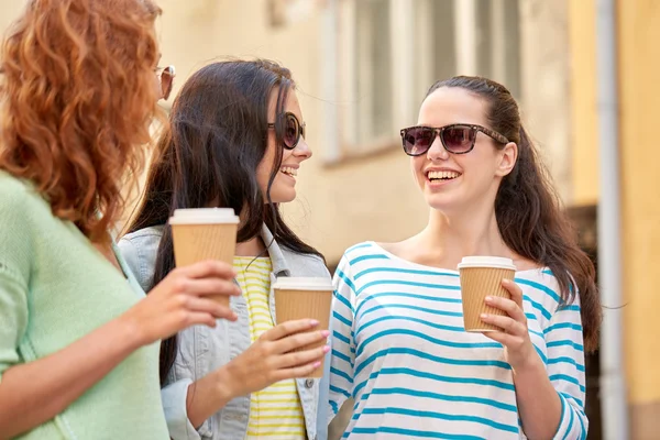 Happy young women drinking coffee on city street — Stock Photo, Image