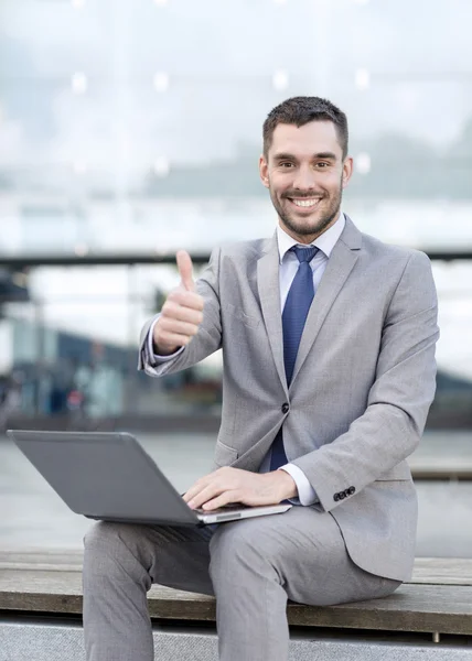 Homme d'affaires souriant travaillant avec ordinateur portable à l'extérieur — Photo