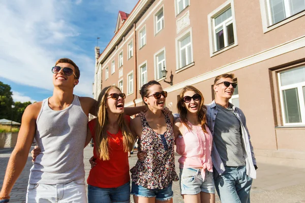 Group of smiling friends walking in city — Stock Photo, Image