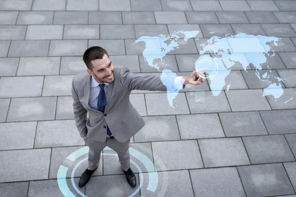 Homem de negócios sorridente com projeção de mapa do mundo — Fotografia de Stock