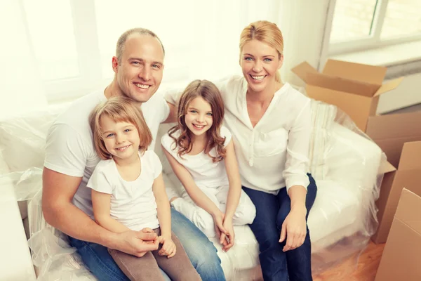 Sonrientes padres y dos niñas en un nuevo hogar —  Fotos de Stock